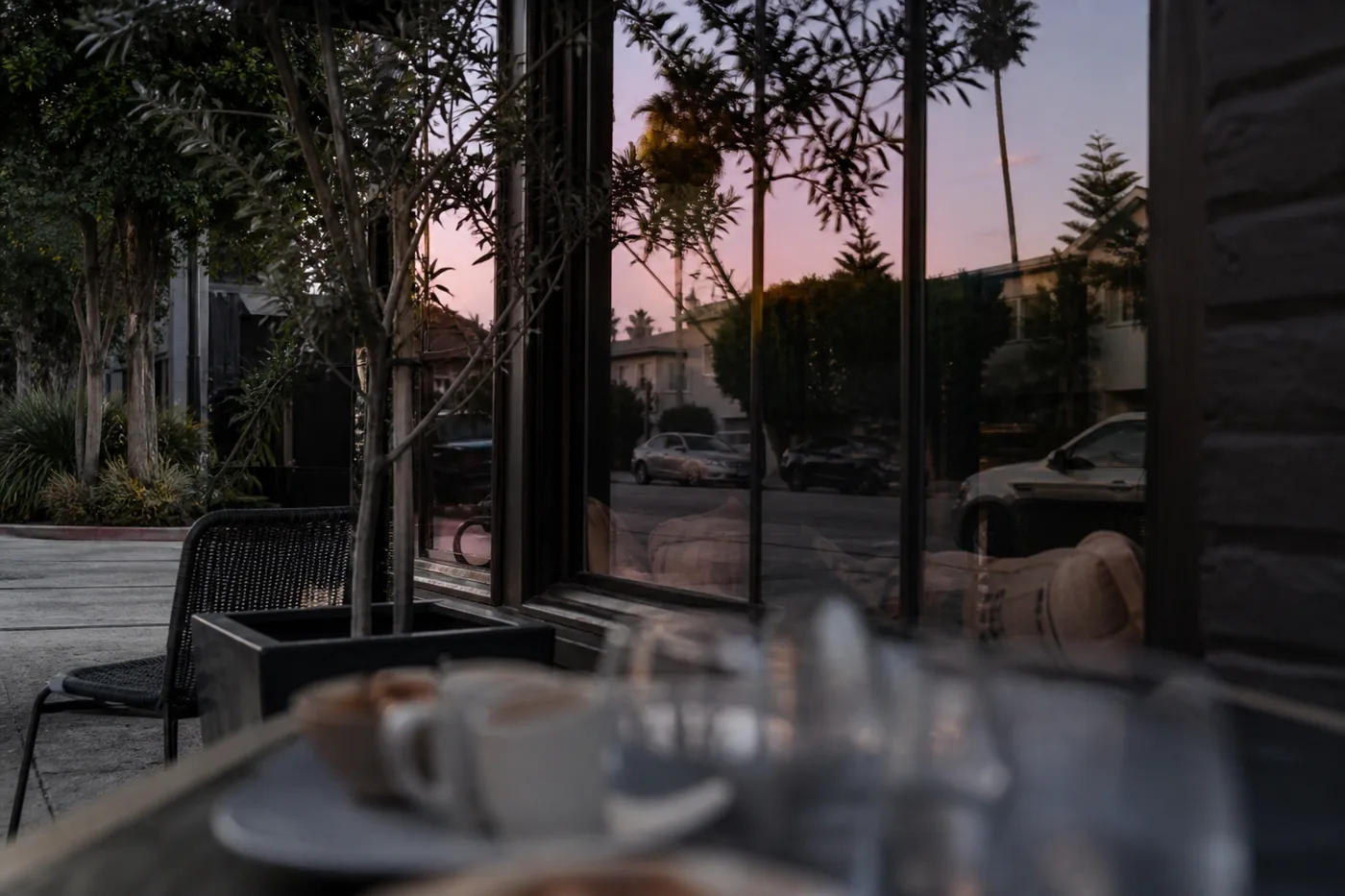 Two people chatting at an outdoor cafe table in a Los Angeles neighborhood